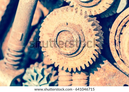 Part of the old mechanism with metal gears, sprockets, other parts covered with rust.Toned photo