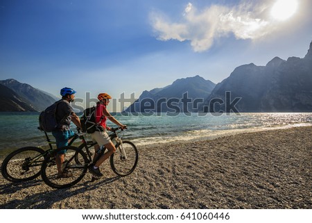 Mountain biking, couple with bikes on Lake Garda, Riva del Garda, Italy