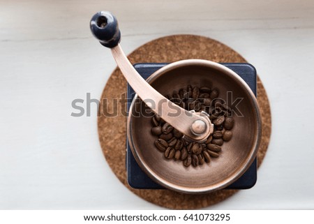 Hand coffee grinder with coffee beans. Top view close-up. Morning cheerfulness