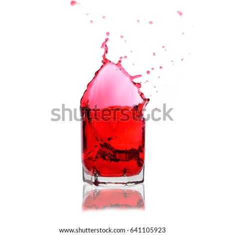 Red cocktail splashing on a glass on white background