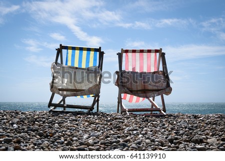 Beach chairs at seaside. She and he relax vacation concept.