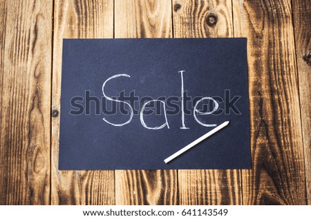 sale sign on chalk board with chalk on wooden background