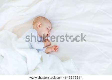 Close-up portrait of adorable baby boy sleeping in bed, 1 year old baby concept Royalty-Free Stock Photo #641171164