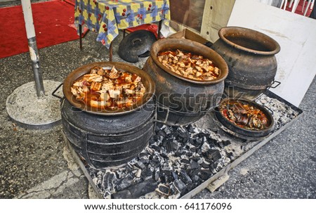 Cooking pork stew in a traditional way in a clay pot.