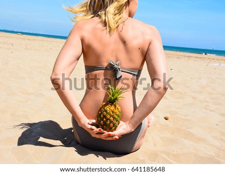 Girl on the beach and near a pineapple 