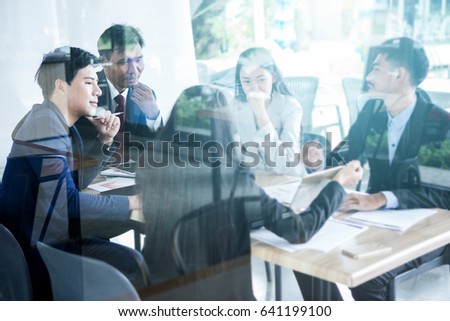 Director, Esecutive manager and officer business people brainstorming in the meeting room, viewed trough the glass door.