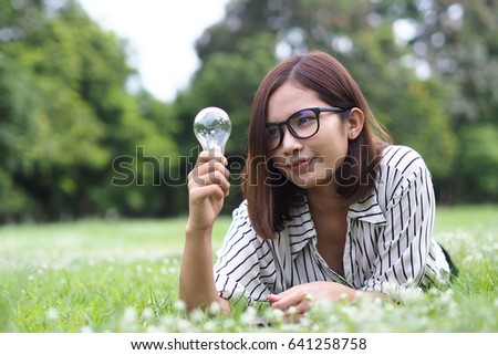 Portrait of a gorgeous young brunette woman with light bulb idea symbol.