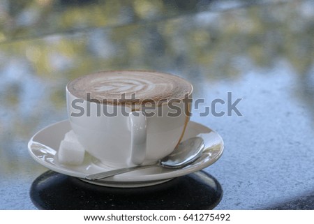 coffee on dark stone table with bokeh nature background