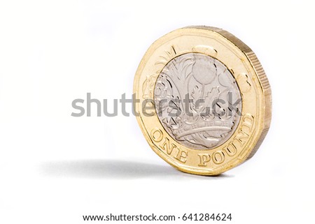 A close-up shot of the new British one pound coin over a white background. Royalty-Free Stock Photo #641284624