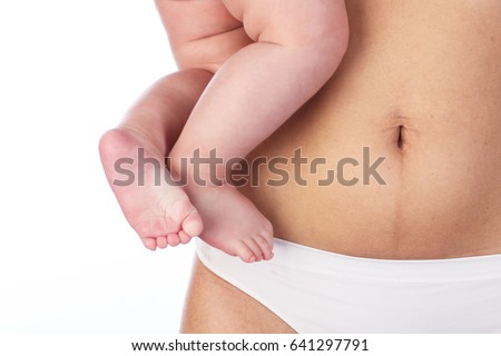 Woman's belly after six months of birth of baby and the baby's legs, on white background