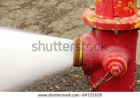 Open 5 inch butt of an industrial fire hydrant being sprayed into a log pod in Creswel Oregon Royalty-Free Stock Photo #64131658