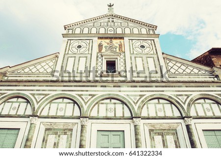 Basilica San Miniato al Monte standing atop one of the highest points in the city. Florence, Tuscany, Italy. Photo filter. Architectural theme.