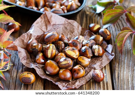 Roasted chestnuts on an old board. Selective focus. Royalty-Free Stock Photo #641348200