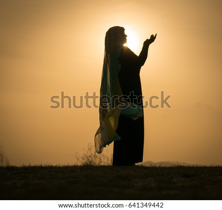 Woman with her hands up on sunset