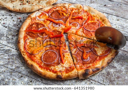 pizza with different toppings. Italian pizza with different sorts of cheese, vegetables and meat on old wooden background close up. Italian traditional food. Popular street food.