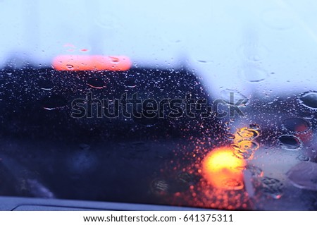 Car lights. Rainy day. Colorful background. Drops on glass.