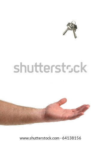 A hand catching a set of keys isolated against a white background