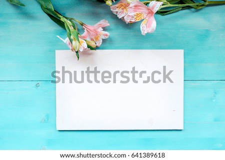 Spring background of bonded wooden boards with a Board of the label layout on a blue wooden background with flowers blackboard