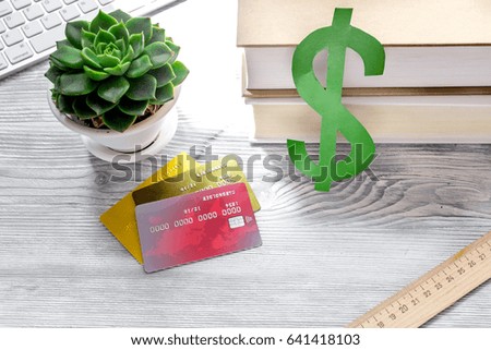 dollar sign and credit cards for fee-paying education on gray student desk background