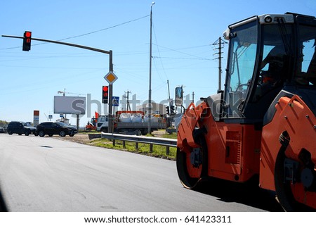 Traffic on the road with a road repair road roller