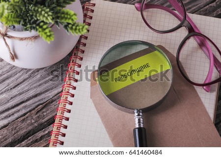Business Concept : RANSOMWARE written on envelope with wooden background