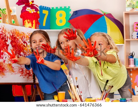 Children painting finger on easel. Small students in art school class. Cheers children in kindergarten. Craft drawing education develops creative abilities of children.