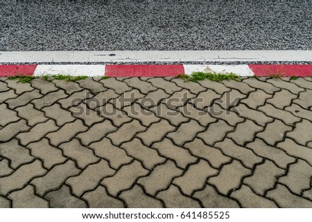 Asphalt road and Concrete block sidewalk with Red and white concrete curb
