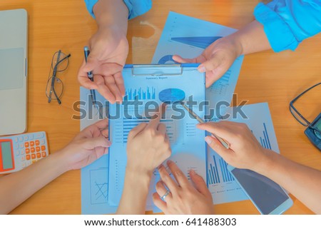 Business meeting, man's hands pointing on charts. Reflection light and flare. Concept image of data gathering and statistical working.