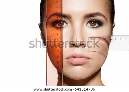 Woman's face is measured with colored rulers before the plastic surgery to change the proportions. Isolated on white background