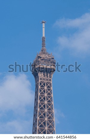 The Tip Of Eiffel Tower With Blue Sky Background. The Eiffel Tower Is A Wrought Iron Lattice Tower On The Champ De Mars In Paris, France.