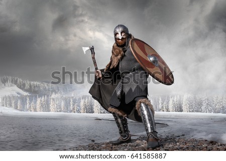 Medieval Scandinavian warrior Viking in full outfit on shore of winter sea Royalty-Free Stock Photo #641585887
