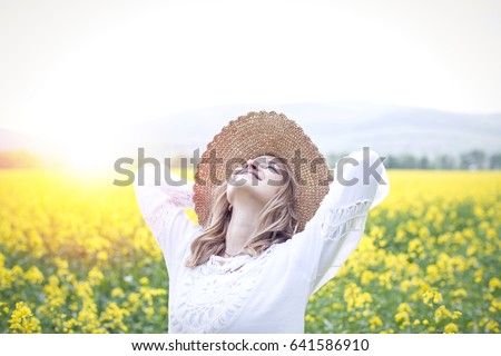 young woman in a rapeseed field Royalty-Free Stock Photo #641586910