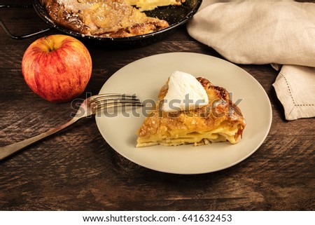 A closeup photo of a piece of a homemade apple pie with a scoop of ice cream, with the rest of the pie in a skillet in the blurred background, with a place for text