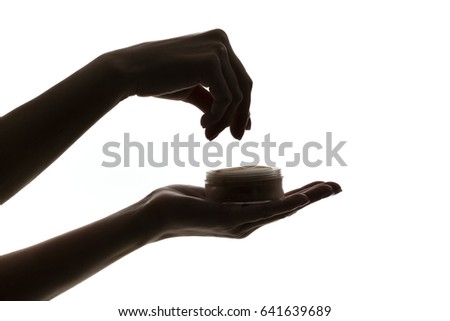 silhouette of female hands holding face powder isolated on white background