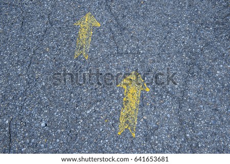 yellow arrows painted on the street for directions