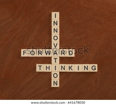 Crossword puzzle with words Innovation, Forward, Thinking. Innovate concept. Ivory tiles with capital letters on mahogany board.