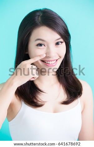 beauty skincare woman smile happily and pointing her nose on green background