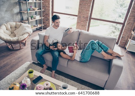 Free time together. Happy beautiful couple is spending weekend together on couch indoors at home, relaxing and enjoying the company of each other Royalty-Free Stock Photo #641700688