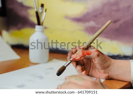 Female hand artist paint with brush a new picture