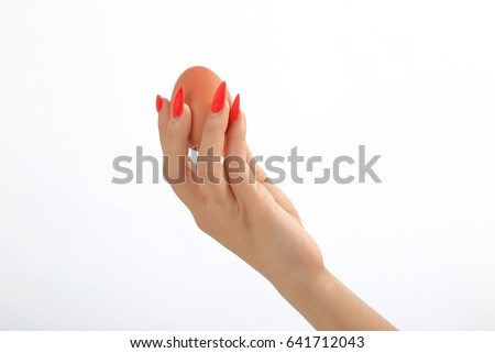 Hand holding egg on white background