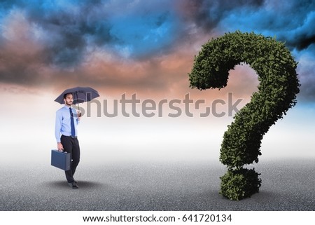 Digital composite of Digital composite image of businessman with umbrella and briefcase walking towards question mark mad