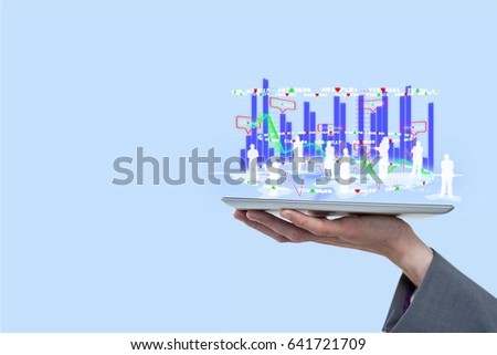 Digital composite of Digital composite image of employees and graphs overs tablet computer held by businessman against bl