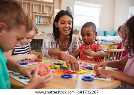 Teacher And Pupils Using Flower Shapes In Montessori School Royalty-Free Stock Photo #641732287