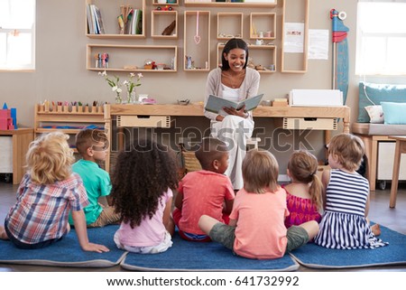 Teacher At Montessori School Reading To Children At Story Time Royalty-Free Stock Photo #641732992