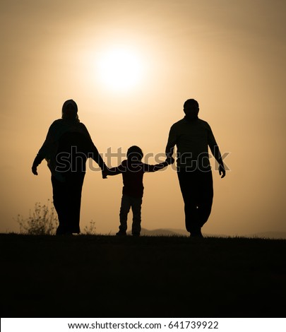 Silhouette of happy family holding each other hands