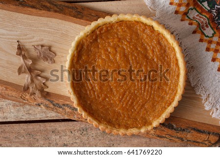 Fresh Homemade Pumpkin Pie made for Thanksgiving. Pie on a wooden background. Rustic.