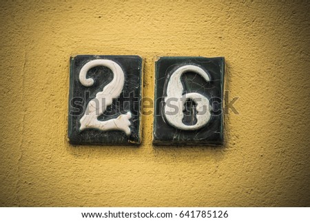 Number twenty six in raised figures on plaster wall