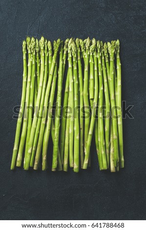 Fresh green asparagus on dark concrete background