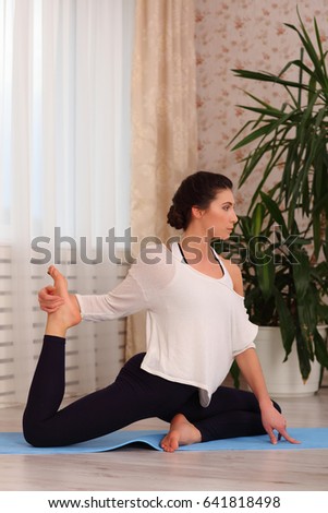 Yoga at home. Keep calm. Attractive young woman sitting on position on floor