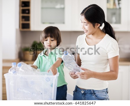 A mother teaching her little boy about the importance of recycling.